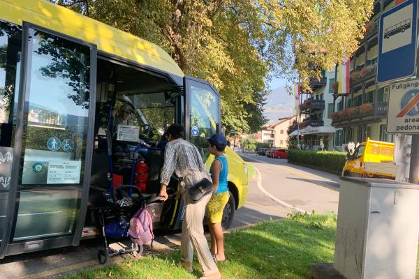 Frau mit Kinderwagen steigt in Citybus ein