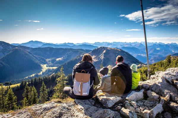 Eltern mit zwei Kindern sitzen auf einem Berg