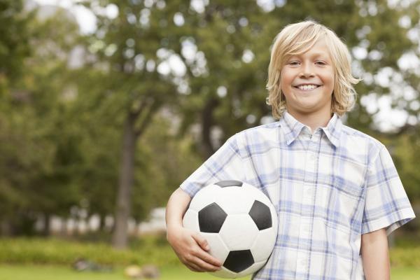 Ein Junge hält einen Fußball